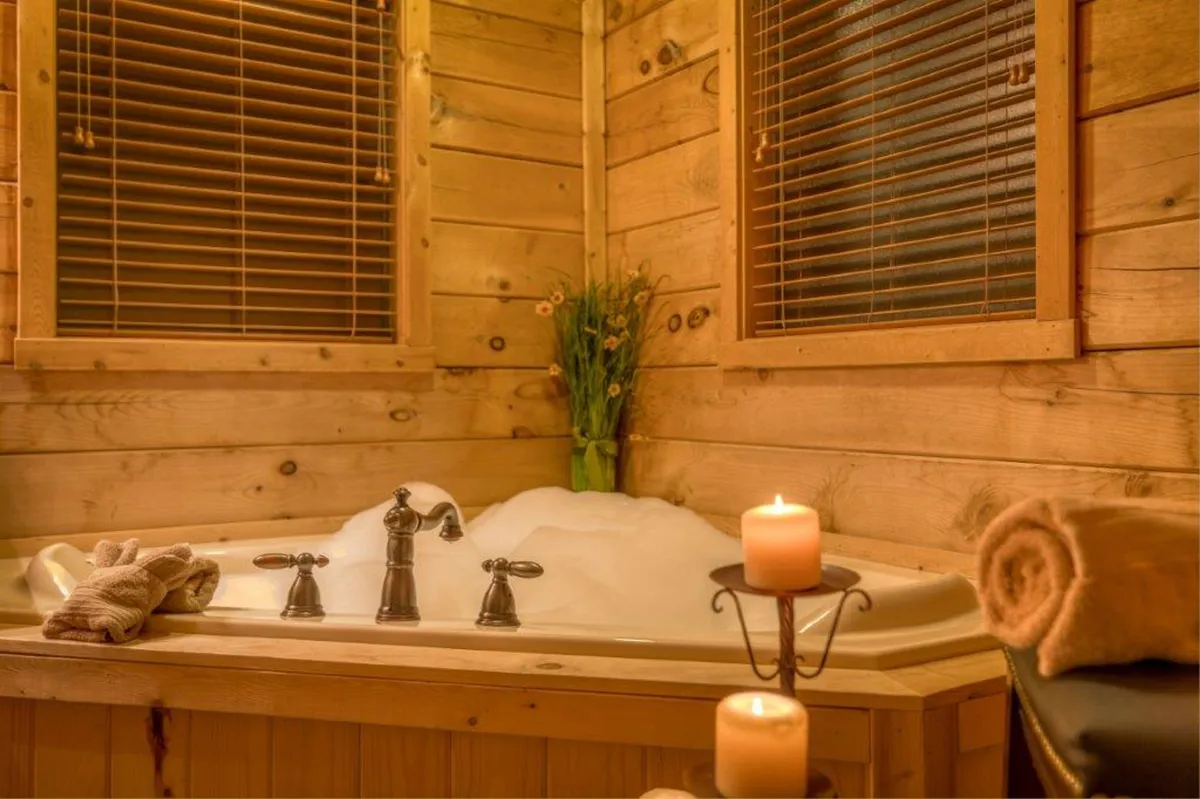 A luxurious bathroom scene featuring a jacuzzi tub surrounded by candles, towels, and plant decoration, evoking a serene and spa-like ambiance perfect for unwinding after a fun-filled day.